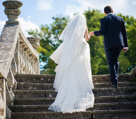 Groom with bride walking near old castle